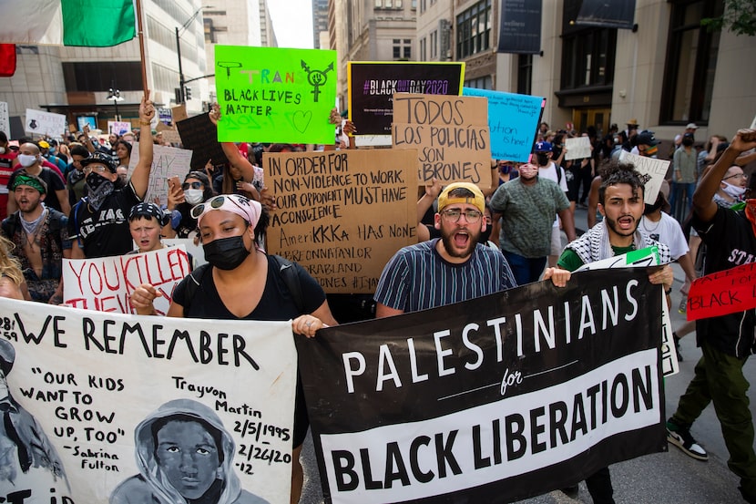 Protestors chant as they march against police brutality and the recent police killings of...