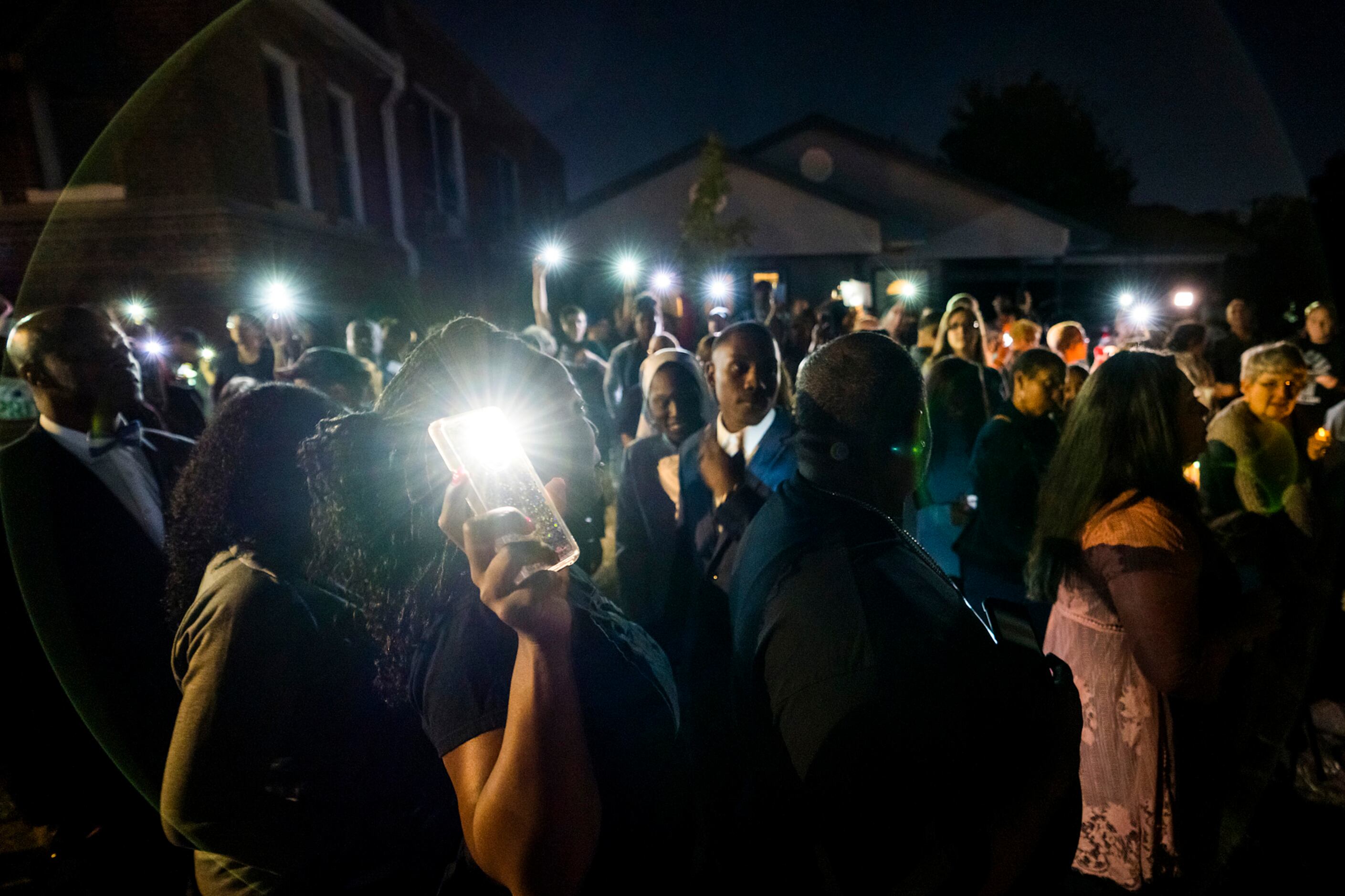 A large crowd gathers outside the house where Atatiana Jefferson was shot and killed, during...