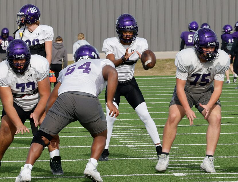 Anna High School quarterback Ziondre Williams, center, receives the ball during their...