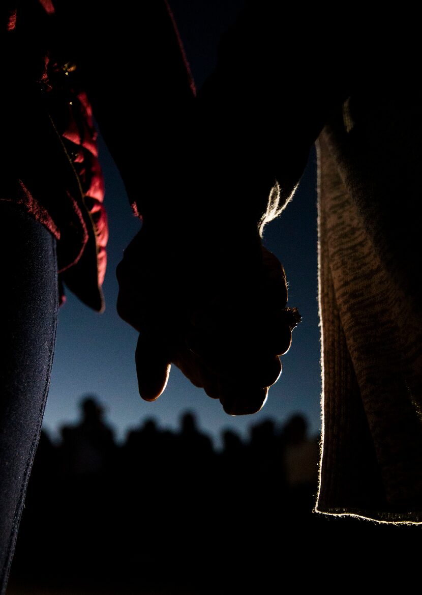 Two women held hands Sunday during a prayer vigil at a memorial for Sherin Mathews behind...