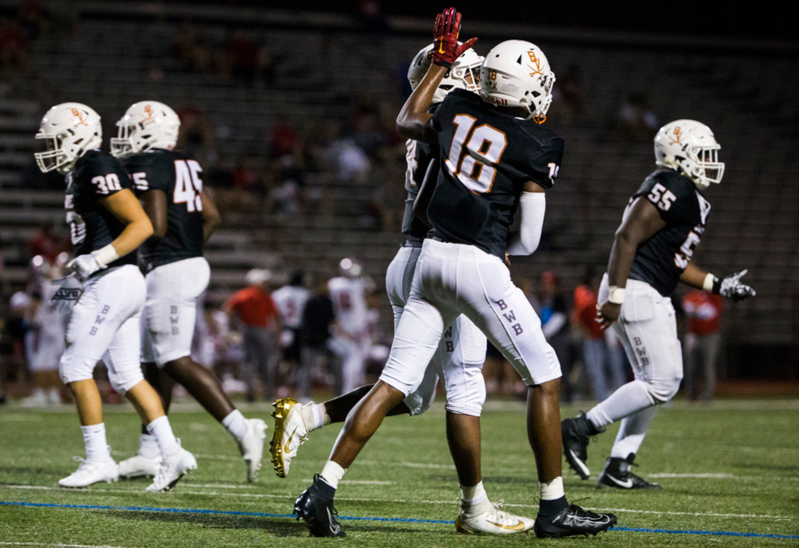 Arlington Bowie quarterback Drevvon Ponder (14) gets a pat on the helmet from wide receiver...