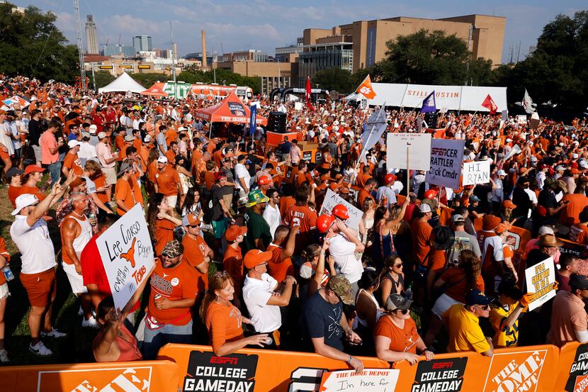 Texas Longhorns and Alabama Crimson Tide fans cheer behind ESPN’s College GameDay outside...