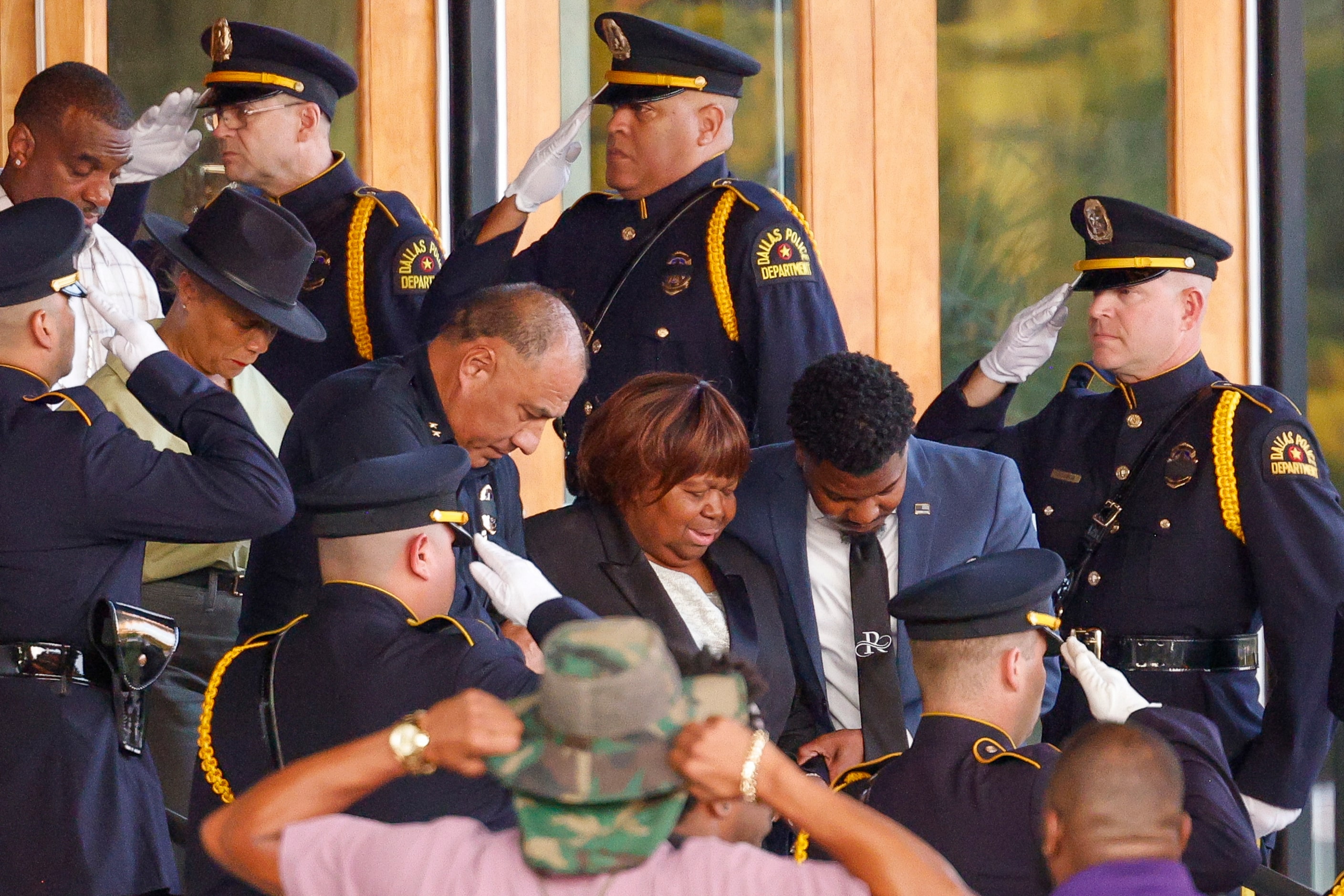 Members of the Dallas police honor guard salute as Officer Darron Burks’ mother Cherie...