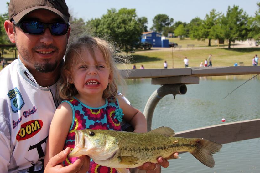 Father and daughter with a potential winner at the annual Rods  n  Raptors fishing event at...