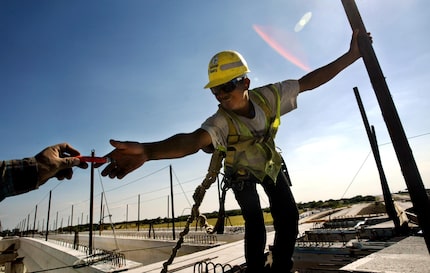 Alexandro Rodriguez, right,  is handed a marker from Marcus Denardo on the southbound Dallas...