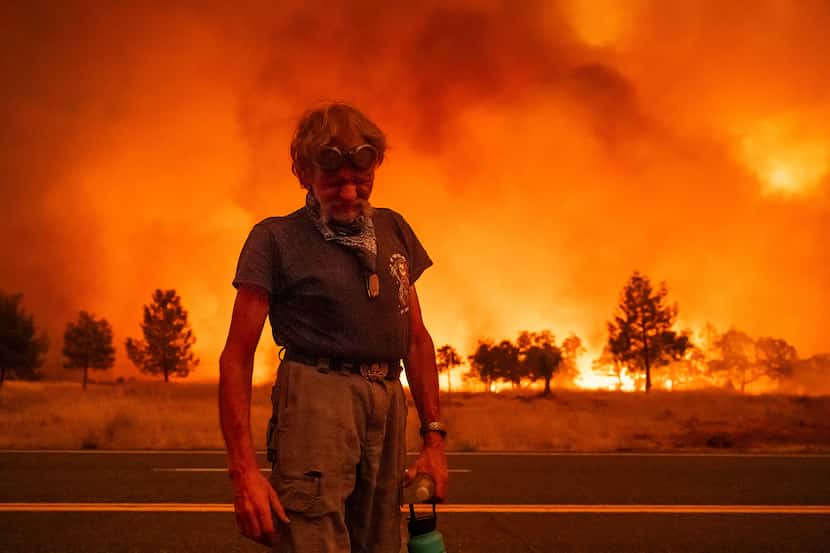 Grant Douglas pauses while evacuating as the Park Fire jumps Highway 36 near Paynes Creek in...