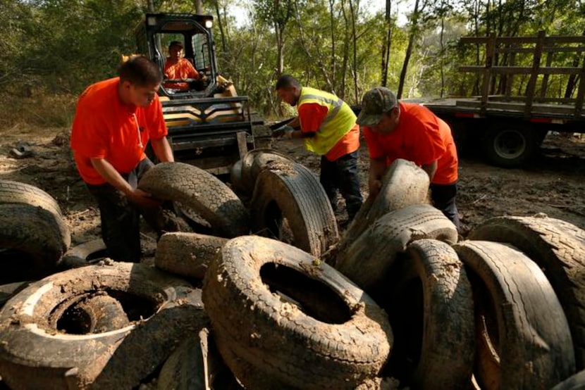 
Removing tires one recent day were Good Earth employees (from left) Eddie Soto, Castro,...