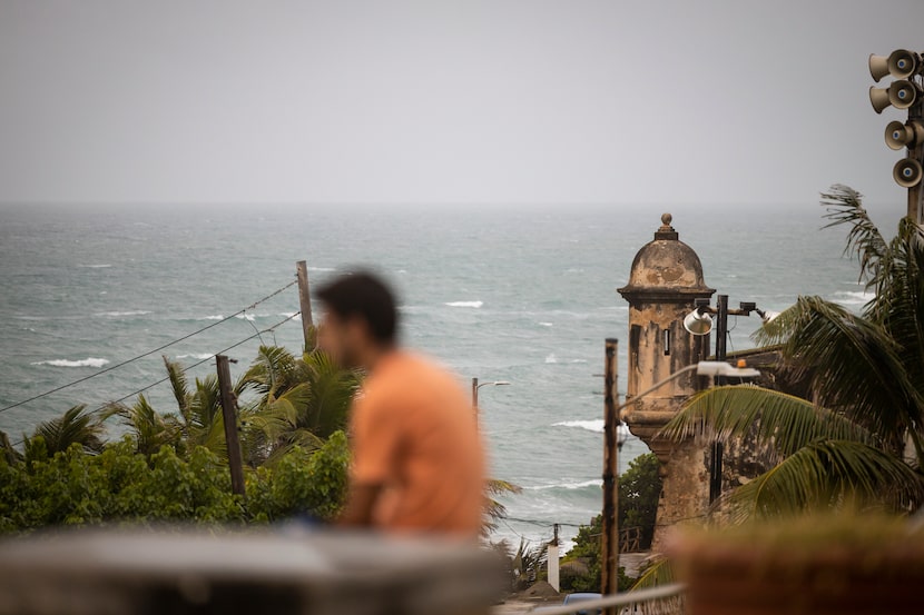 A man stands in front of a beach before the arrival of Tropical Storm Fiona in San Juan,...