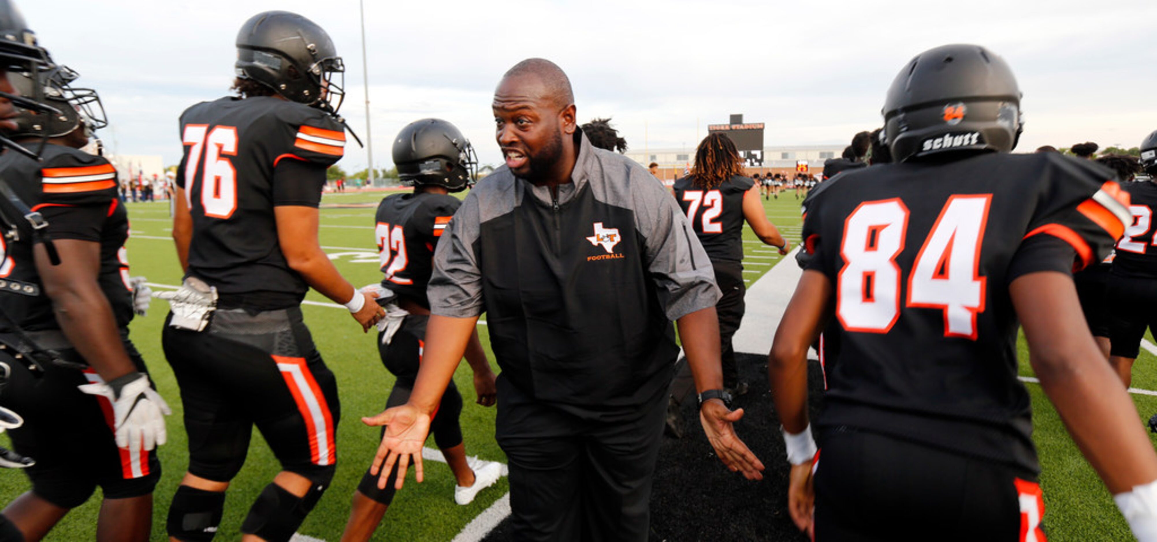 Lancaster head coach Christopher Gilbert slpas hands with his players after the team's...