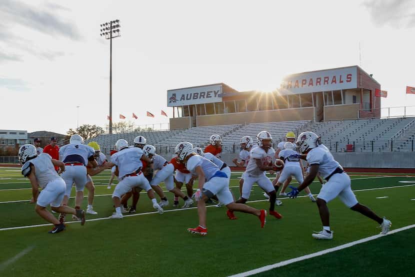 The Aubrey football team runs a play during a football practice at Aubrey High School on...
