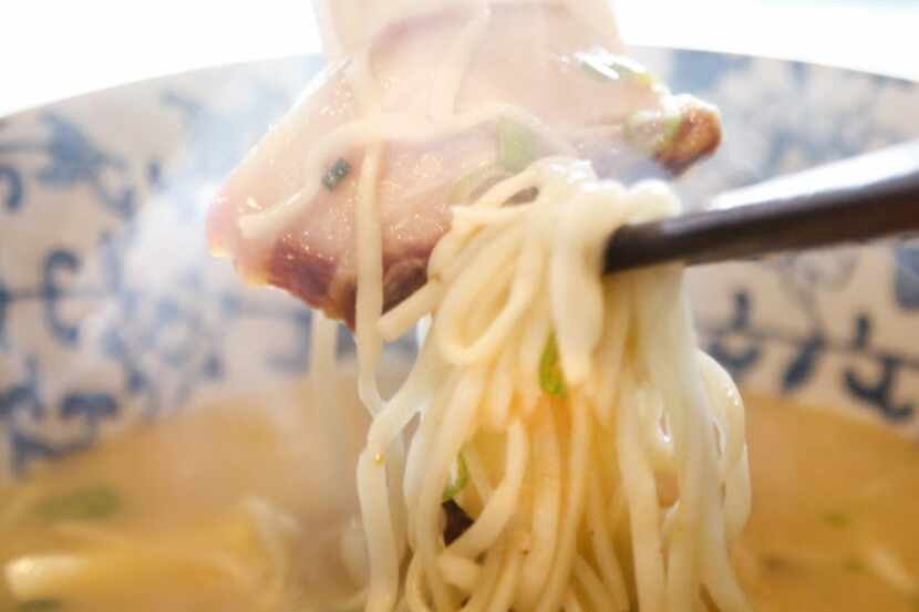 Buck Phan eats his Tonkotsu ramen using spoon and chopsticks at the Tanoshii Ramen + Bar in...