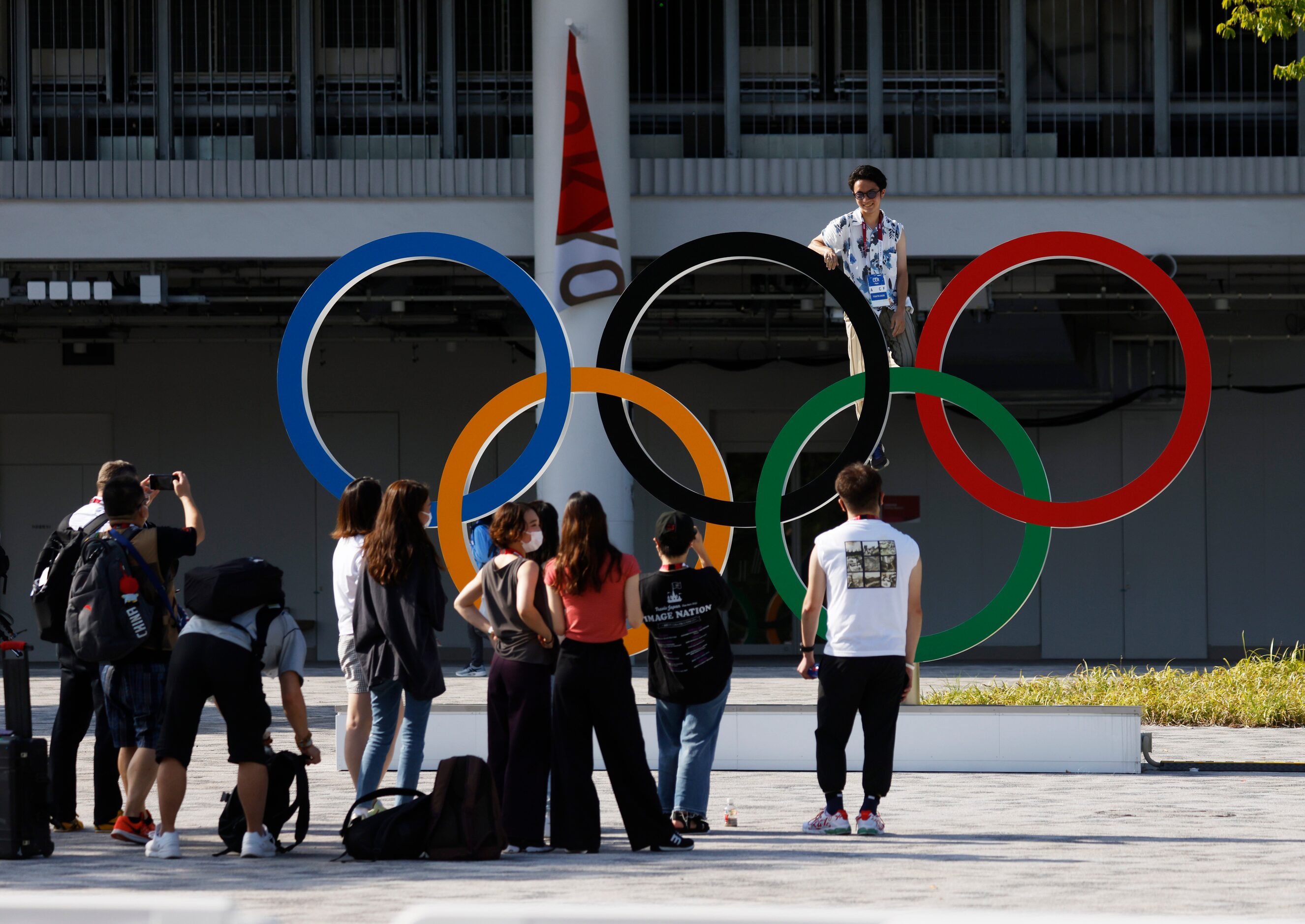 People pose with Olympic rings during the postponed 2020 Tokyo Olympics in front of Olympic...