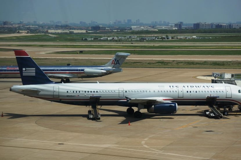  US Airways and American Airlines airplanes pass by at Dallas/Fort Worth International...