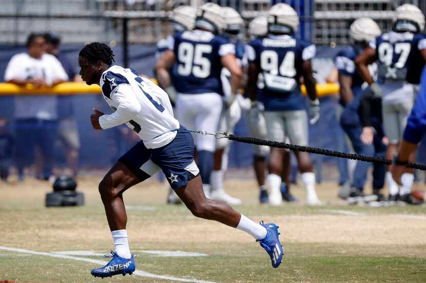 Dallas Cowboys wide receiver Michael Gallup (13) uses a resistance cord to work on his...
