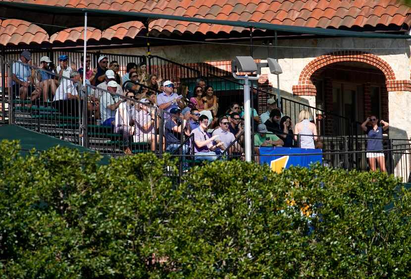 Golf fans fill bleachers built outside the 16th tee box as they applaud PGA Tour golfer...