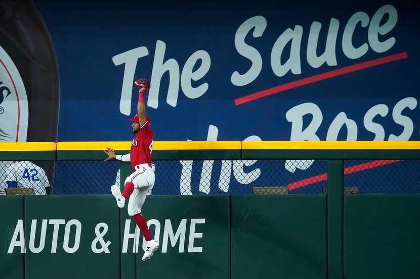 Texas Rangers center fielder Leody Taveras makes a leaping catch at the wall to take a home...