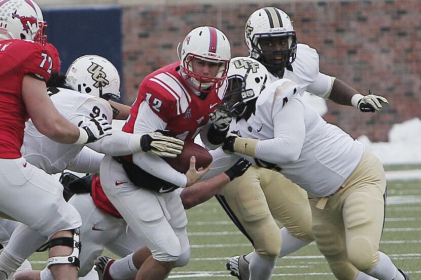 SMU quarterback Neal Burcham (12) is sacked by the UCF defense during the second half of an...