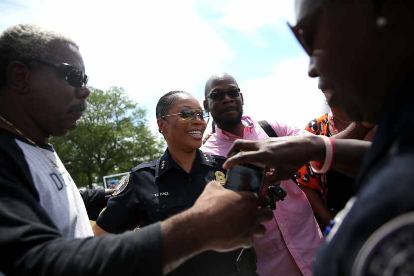 Community members pass a phone to take photos of themselves with Detroit Deputy Chief and...