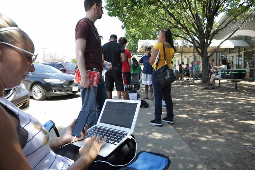 Autumn Bright worked on her laptop while she waited outside in the summer heat on Aug. 16 at...