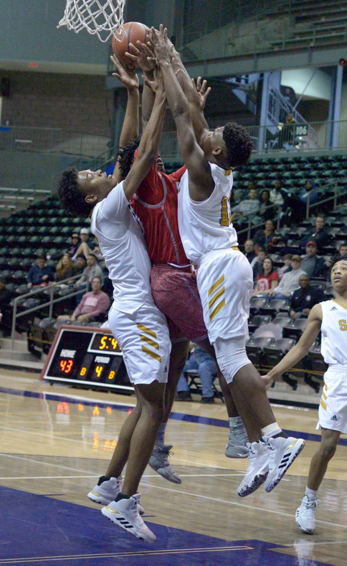 Woodrow Wilson's Josh Robertson (in red) goes up for a shot between South Oak Cliff's in the...