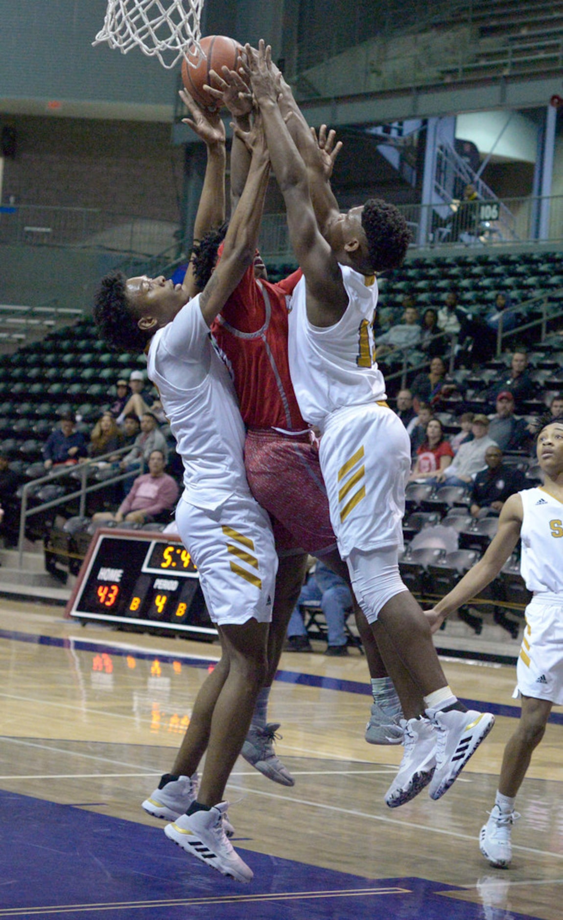 Woodrow Wilson's Josh Robertson (in red) goes up for a shot between South Oak Cliff's in the...