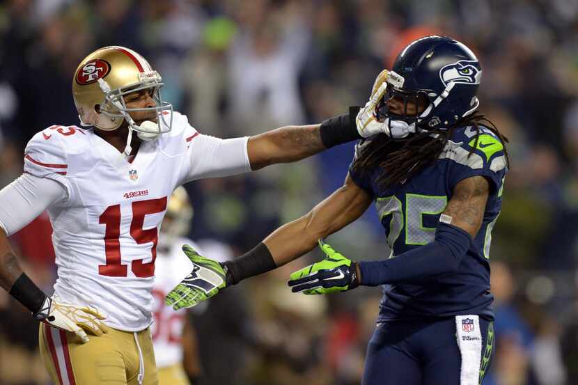 Seattle Seahawks cornerback Richard Sherman (25) gets shoved in the face by San Francisco...