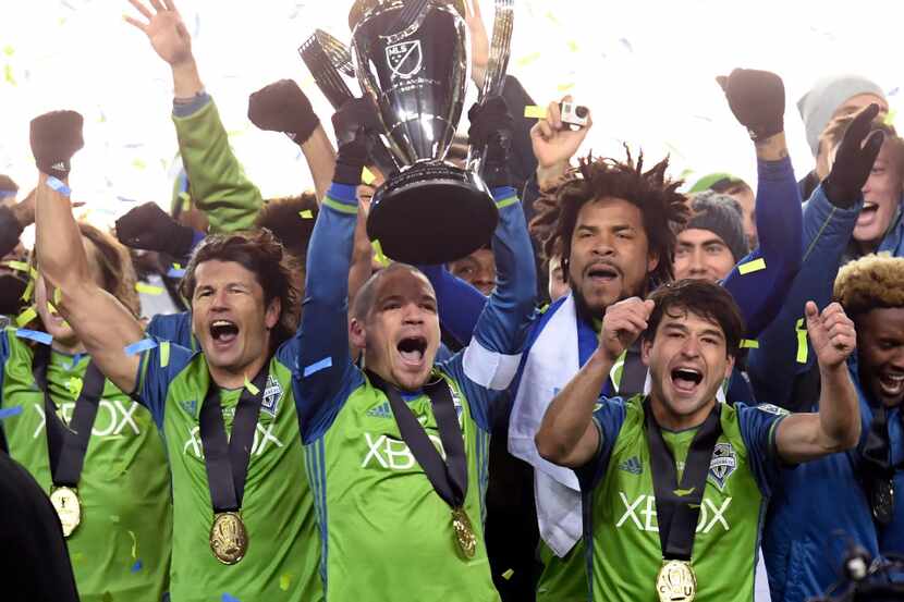 Members of the Seattle Sounders celebrate after winning the MLS Cup soccer final over...