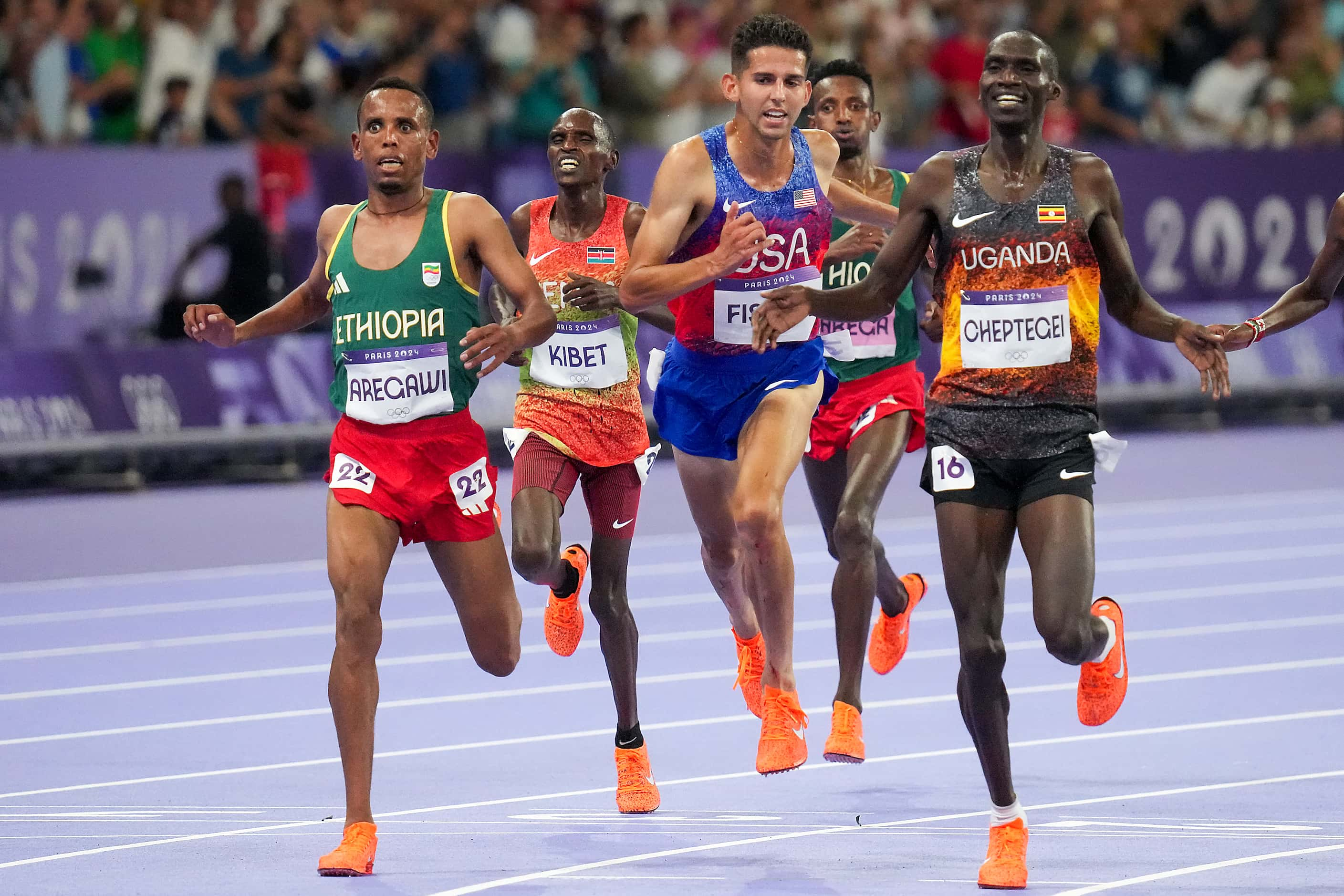 Grant Fisher of the United States leans in to win the bronze medal after gold medalist...