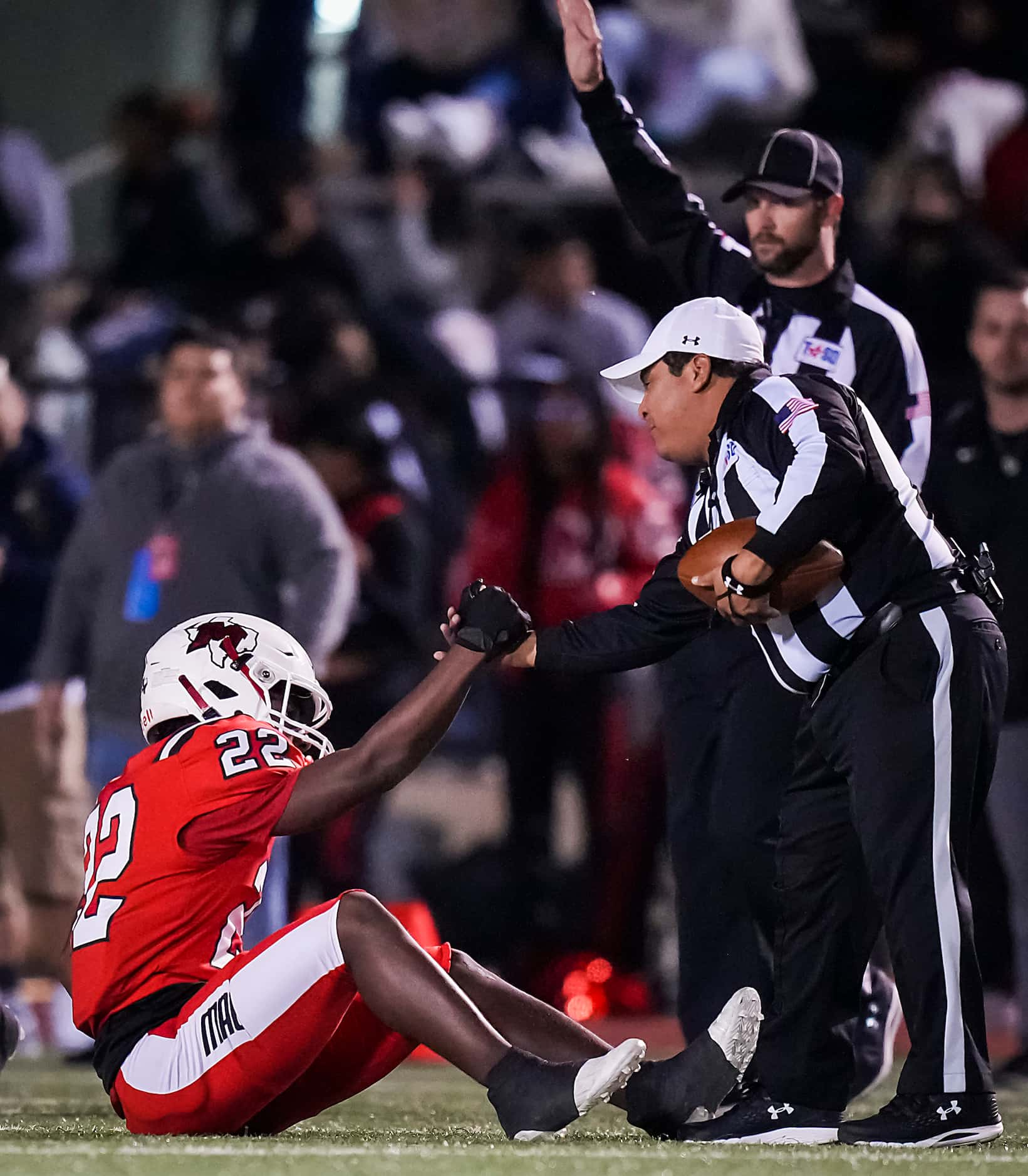 Irving MacArthur’s Jerbrandin Henderson (22) gets a hand up from an official during the...