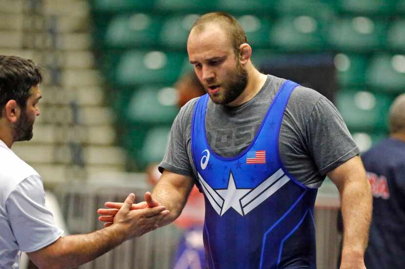 Tervel Dlagnev of the USA wrestling team, is congratulated by a member of the training staff...
