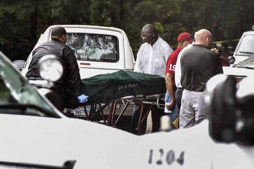 Investigators remove one of the bodies from the scene of a double shooting outside a Tyler...