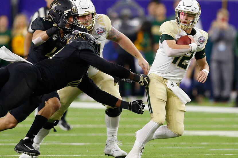 HOUSTON, TEXAS - DECEMBER 27: Charlie Brewer #12 of the Baylor Bears avoids the sack attempt...