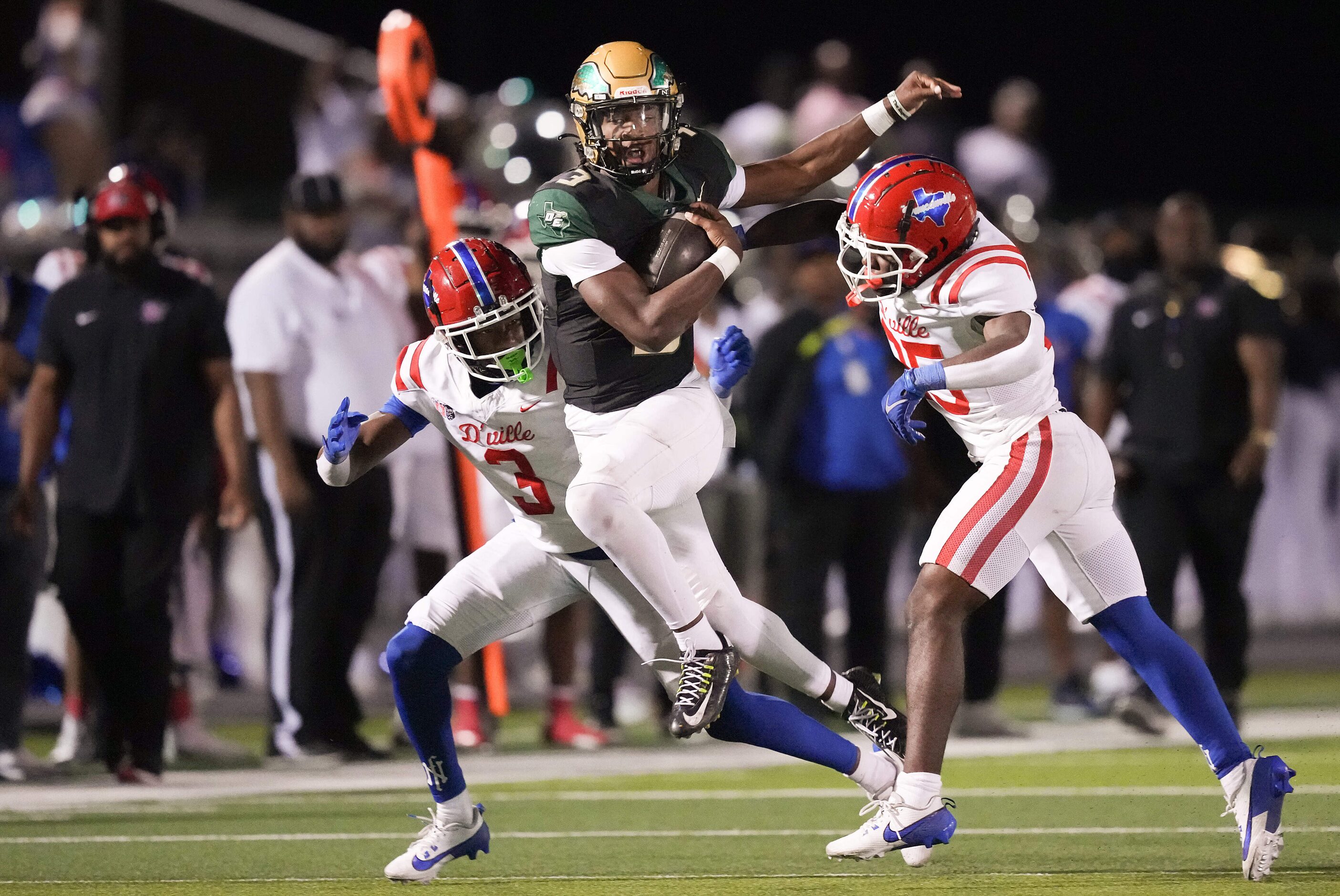 DeSoto quarterback Kelden Ryan (3) is brought down by Duncanville defensive backs Javion...