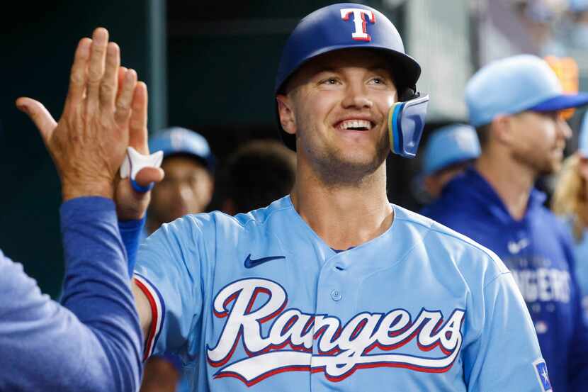 Texas Rangers third baseman Josh Jung cheers in the dugout after scoring a home run during...