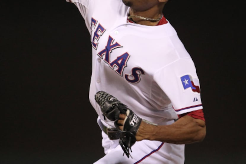 Texas Rangers relief pitcher Alexi Ogando (41) throws in the ninth inning against the...
