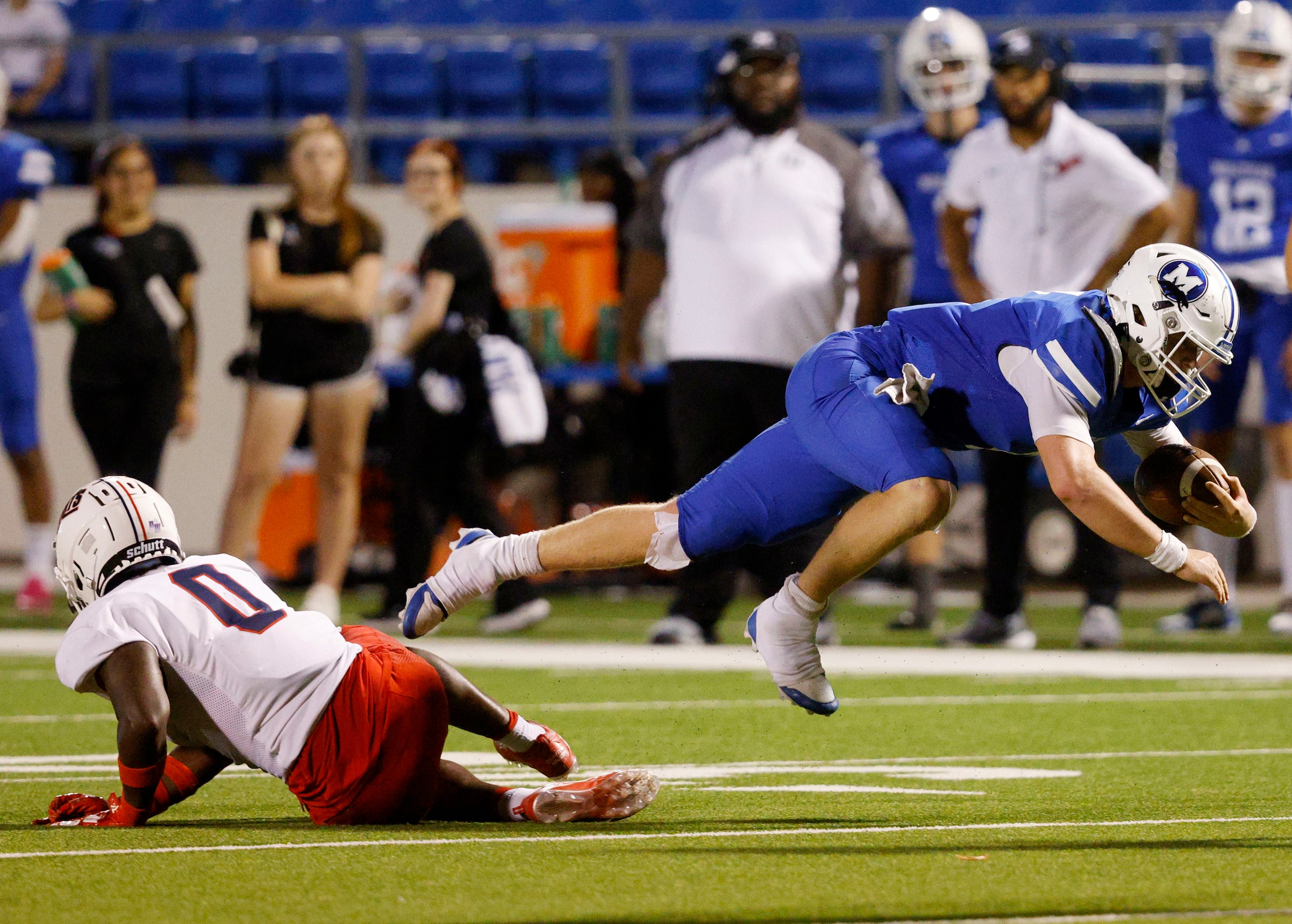 Midlothian's quarterback Beau Wendel (4) jumps over Kimball's William Carrigan (0) in the...