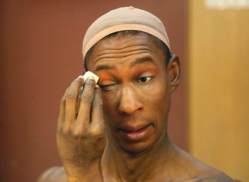 
Ivan Jones of Dallas applies make up in a dressing room mirror as he transforms himself...