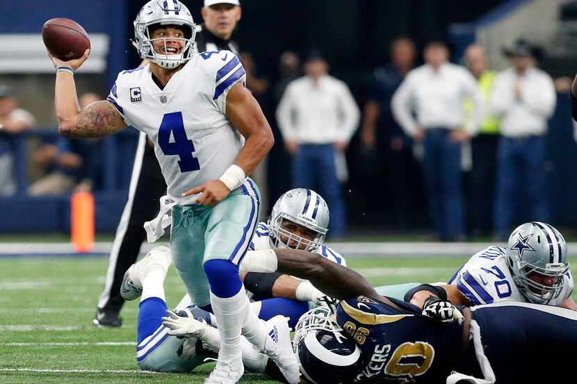 Dallas Cowboys quarterback Dak Prescott (4) releases a last second pass as he escapes the...