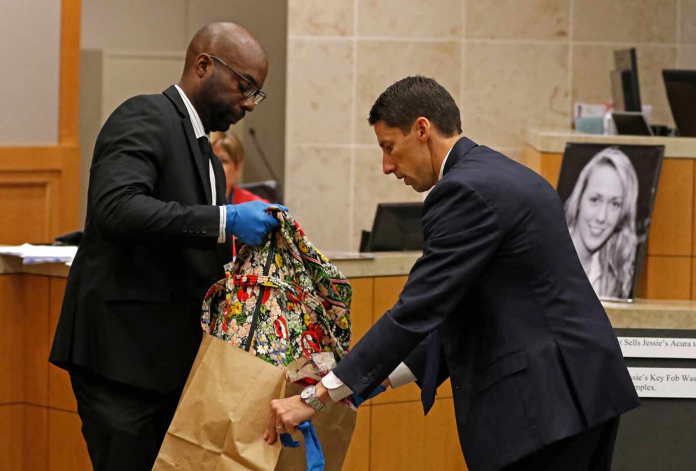 Prosecutor Wes Wynne (right) helps Richardson police Detective Chiron Hale pull out a floral...