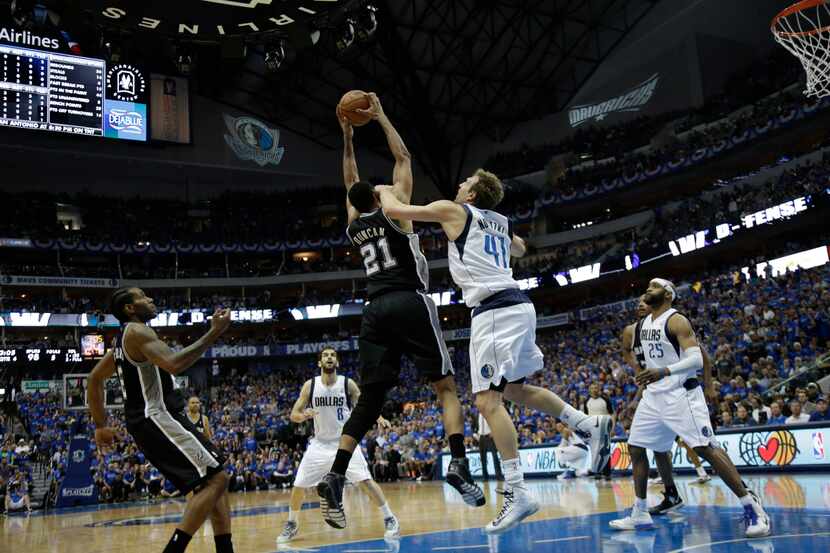 Dallas Mavericks forward Dirk Nowitzki fouls San Antonio Spurs forward Tim Duncan (21)...