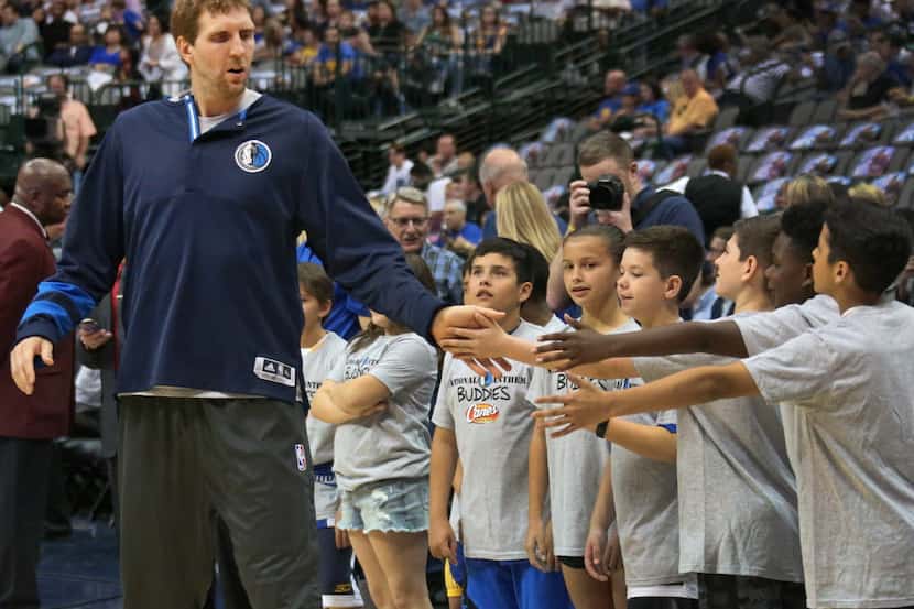 Dallas Mavericks forward Dirk Nowitzki (41) shakes hands with youngsters during warmups...