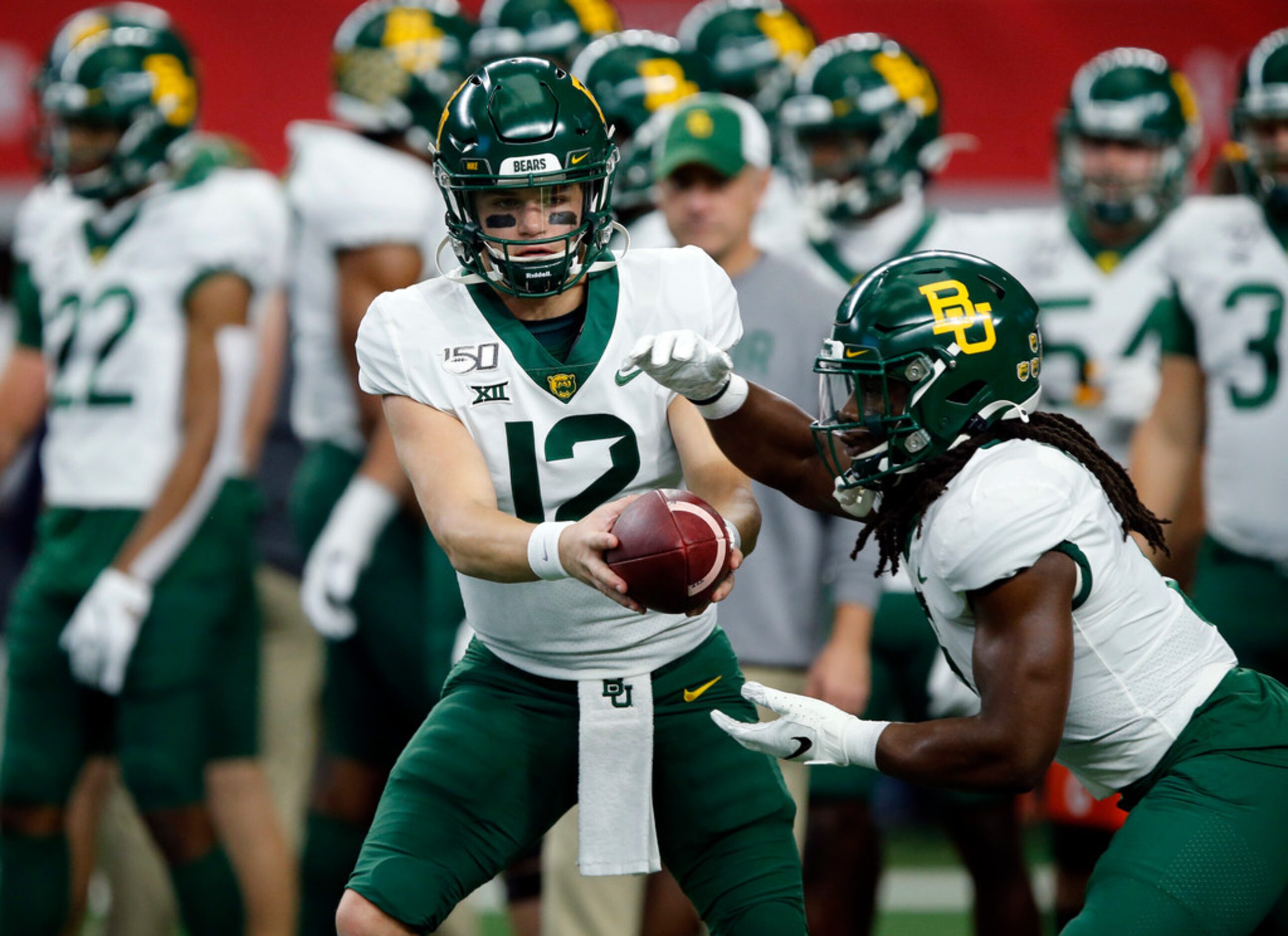 Baylor Bears quarterback Charlie Brewer (12) hands the ball off to running back JaMycal...