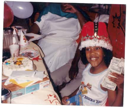 Playwright Jonathan Norton holds up money while opening presents during a childhood birthday...