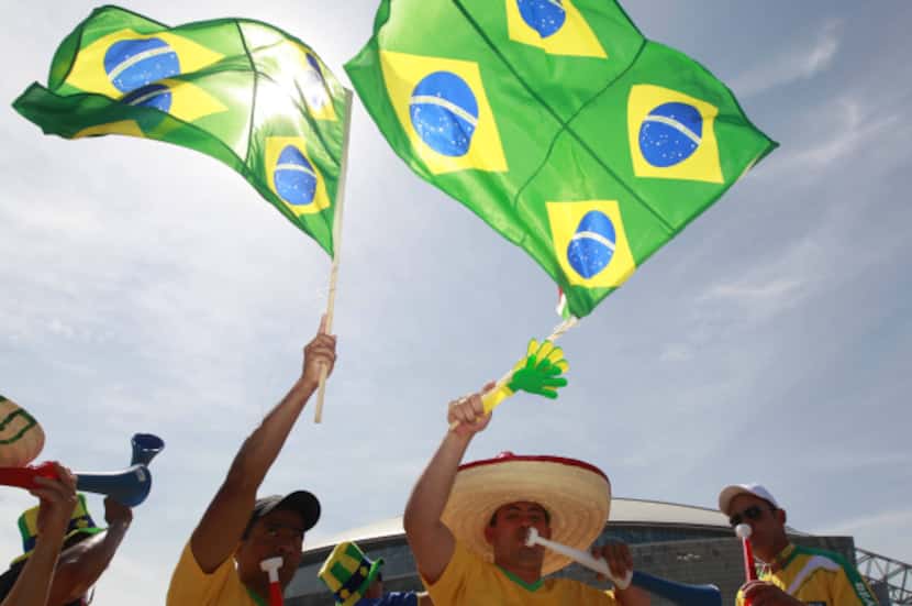 Brazil fan Fabio William of Baton Rouge (center) makes noise before the start of Sunday's...