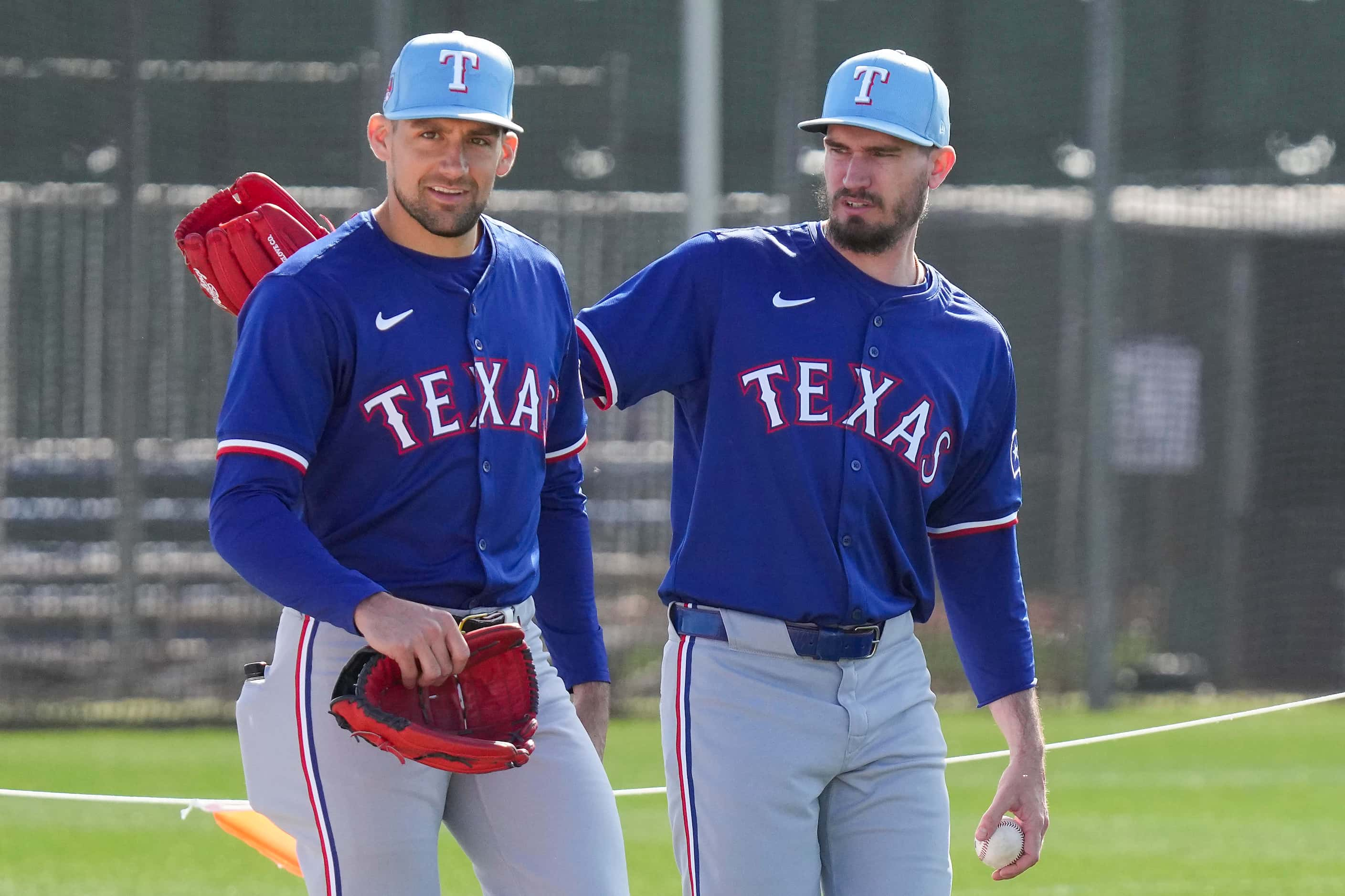 Texas Rangers pitcher Nathan Eovaldi (left) and pitcher Andrew Heaney walk between drills...