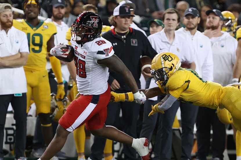 Texas Tech running back Tahj Brooks (28) runs past Baylor cornerback Chateau Reed (21) in...