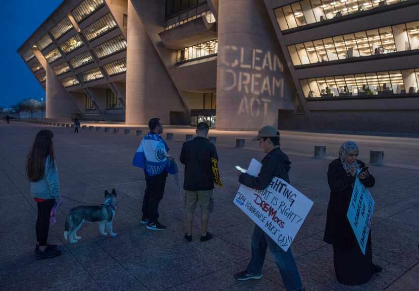 A slogan reading "Clean Dream Act" is projected on Dallas City Hall during a DACA protest...