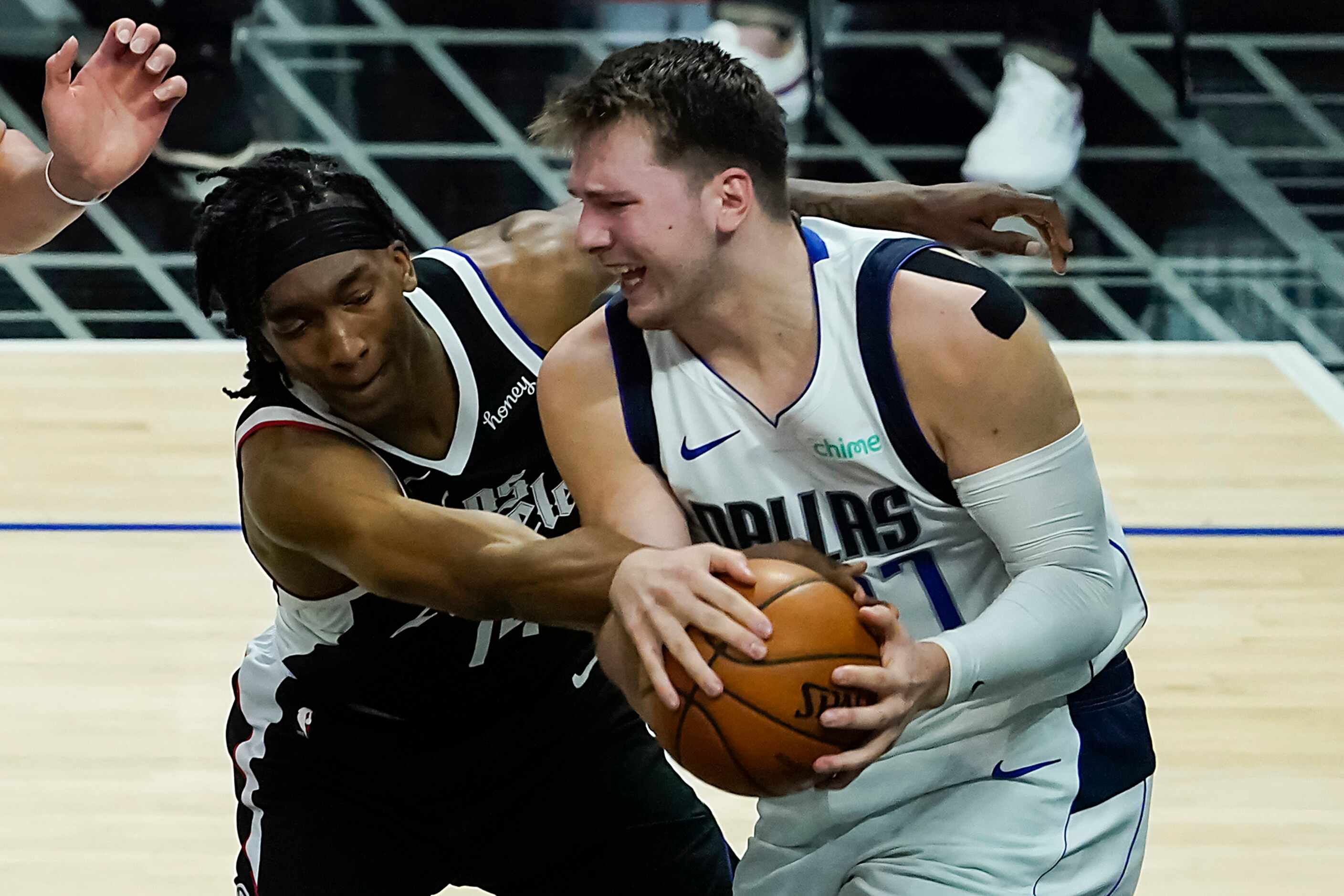 Dallas Mavericks guard Luka Doncic (77) wrestles a rebound away from LA Clippers guard...