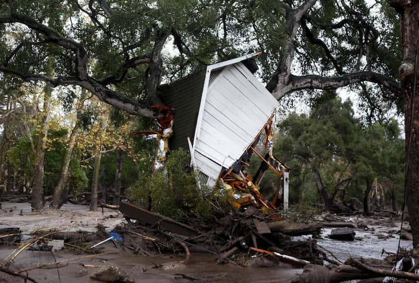 A structure is smashed against a tree along Hot Springs Road in Montecito, Calif. after...