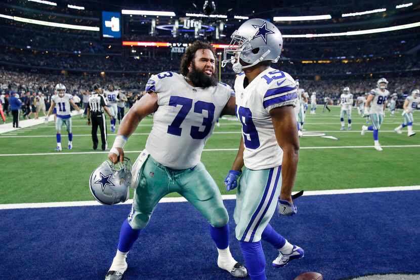 FILE - Cowboys receiver Amari Cooper (19) is congratulated by center Joe Looney (73) after...